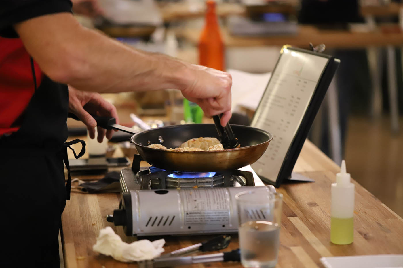 A corporate team cooking fresh pot stickers at our corporate party venue in Tampa, FL.