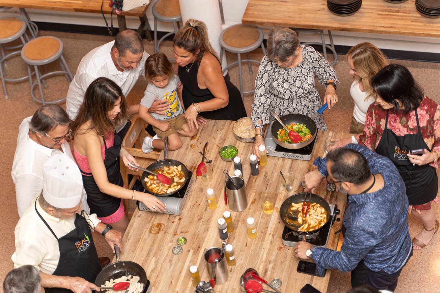 A group of people eating different foods - discover new flavors with The Real Food Academy's healthy cooking lessons.
