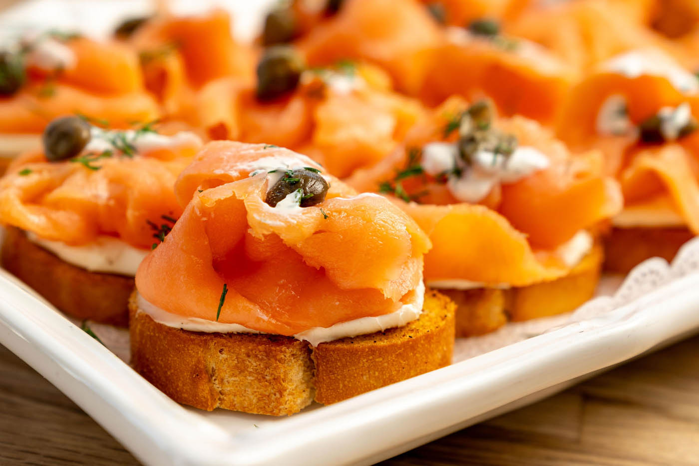 Smoked salmon with a side of capers in a white plate at The Real Food Academy Tampa.