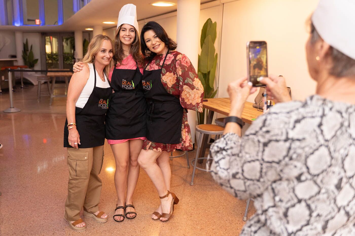 A group of girlfriends smiling at a private event in The Real Food Academy.
