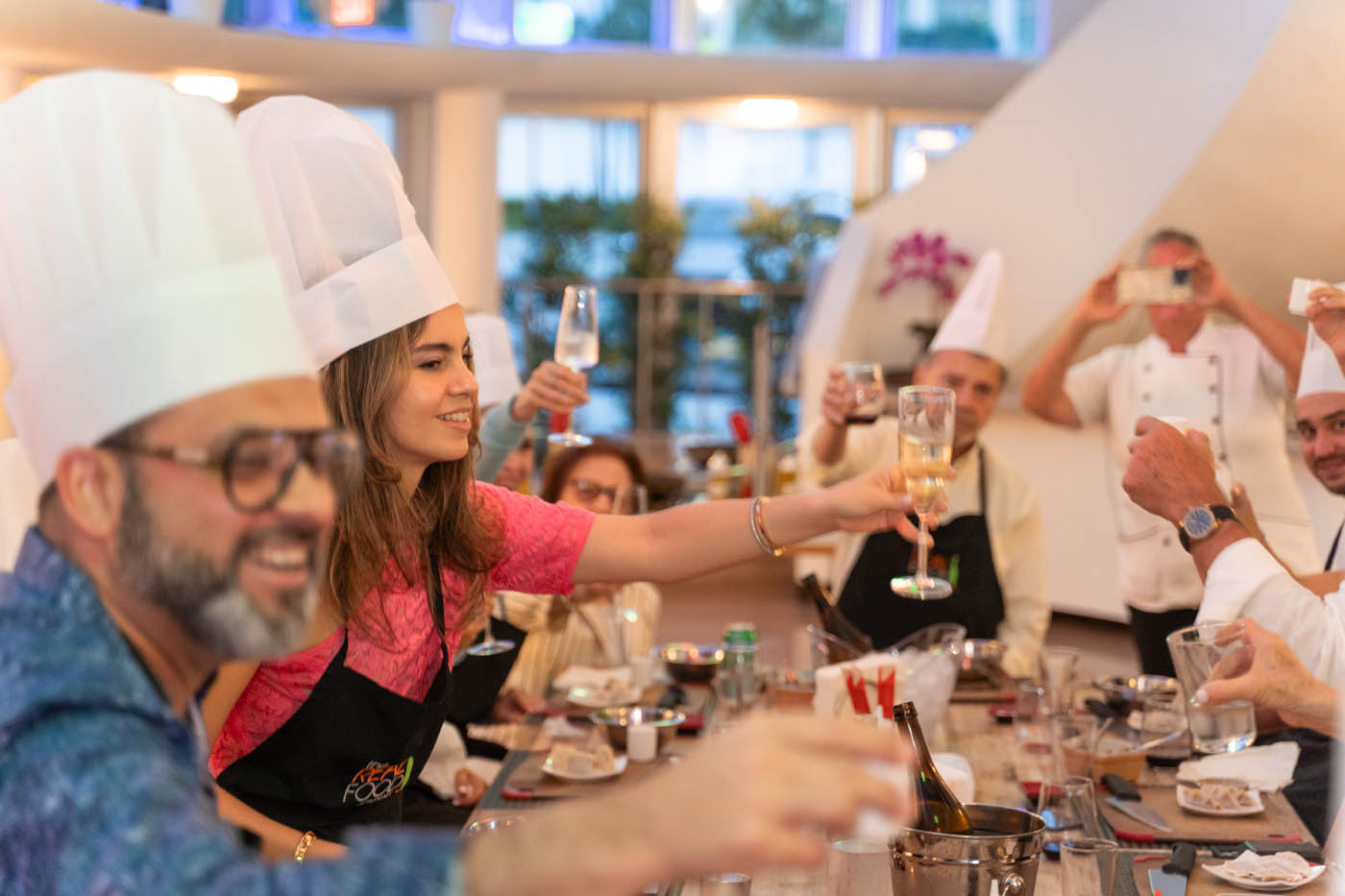 A group of adults cheering a drink at The Real Food Academy.